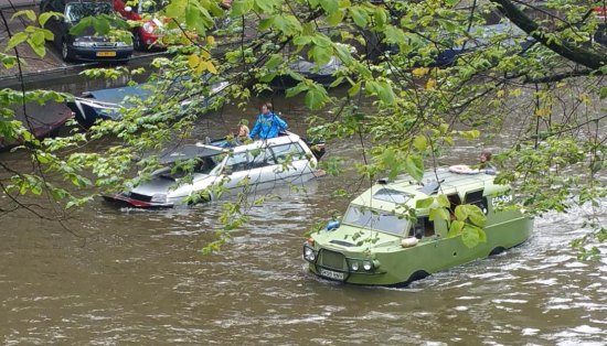 Gespot: flinke stoet amphicars in de Amsterdamse grachten